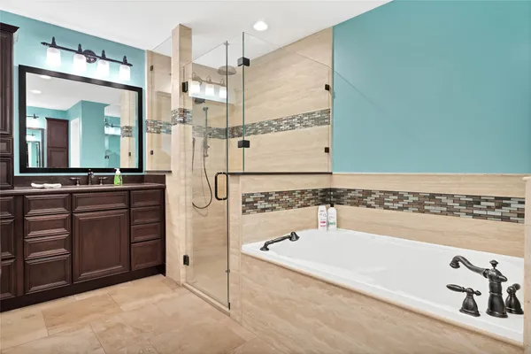 a bathroom with a tub a sink and a mirror