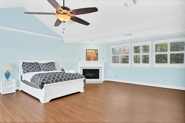a spacious bedroom with a large bed chandelier and a fireplace
