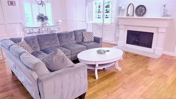 a living room with furniture a fireplace and a large window