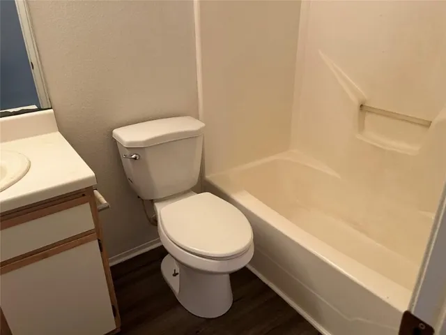 a white toilet sitting next to a bath tub