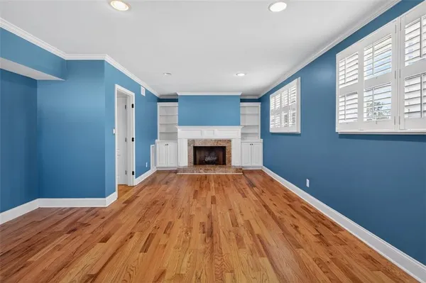 a view of empty room with wooden floor and fireplace