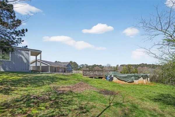 a view of a house with a big yard and large trees