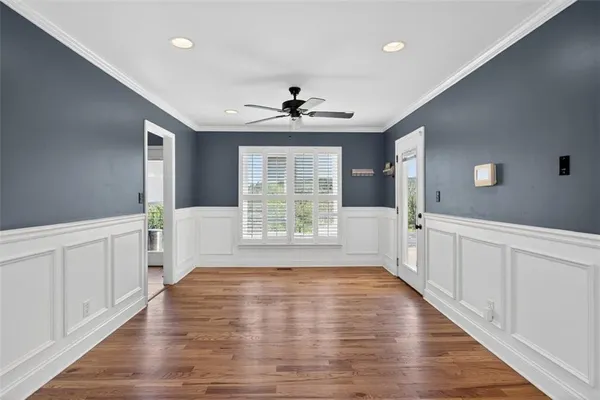a view of an empty room with window and wooden floor