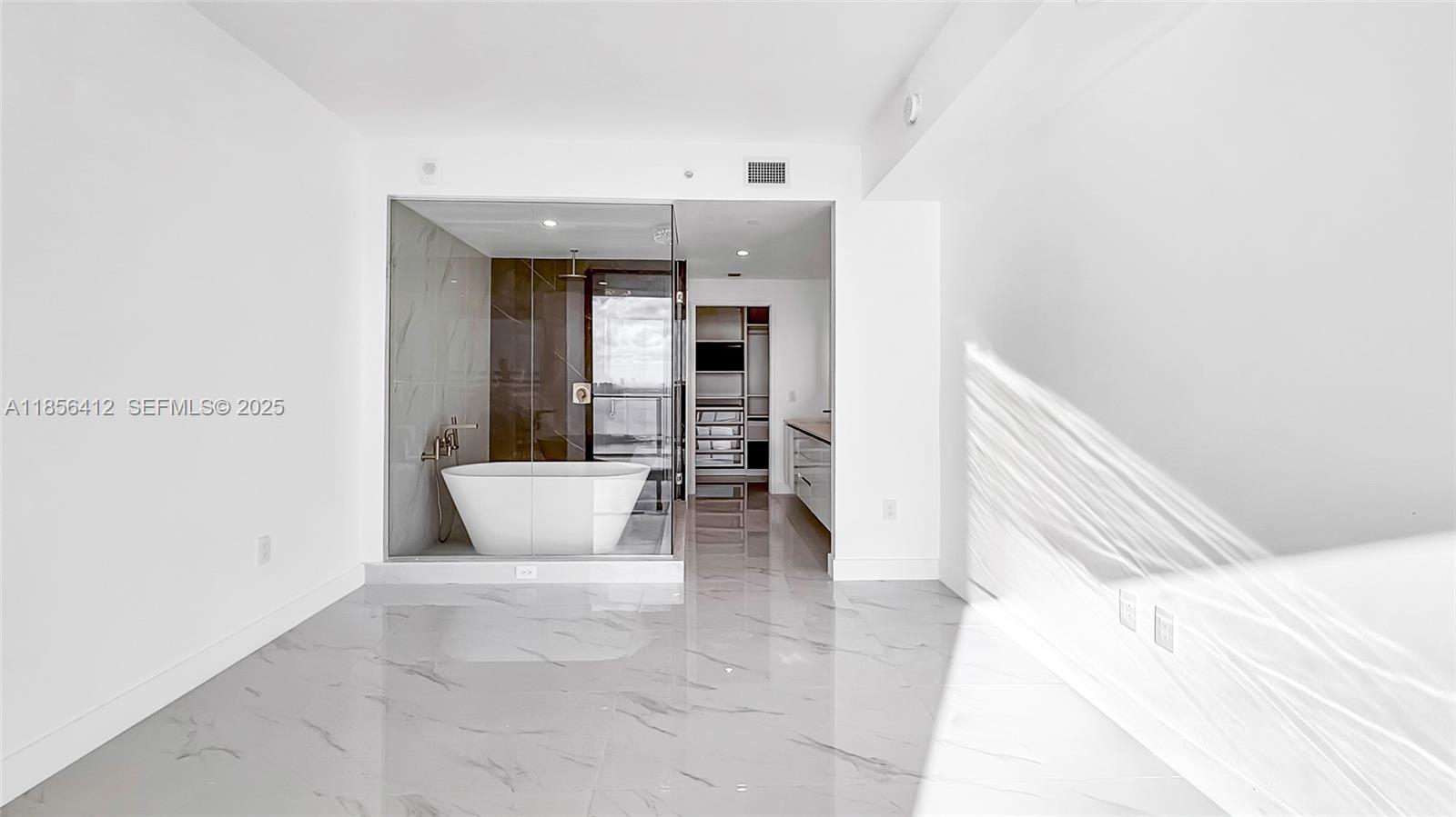 700 Northeast 24th Street, Unit 2704 Miami, FL 33137 - Photo 26 of 88 a living room with a white couch and a potted plant