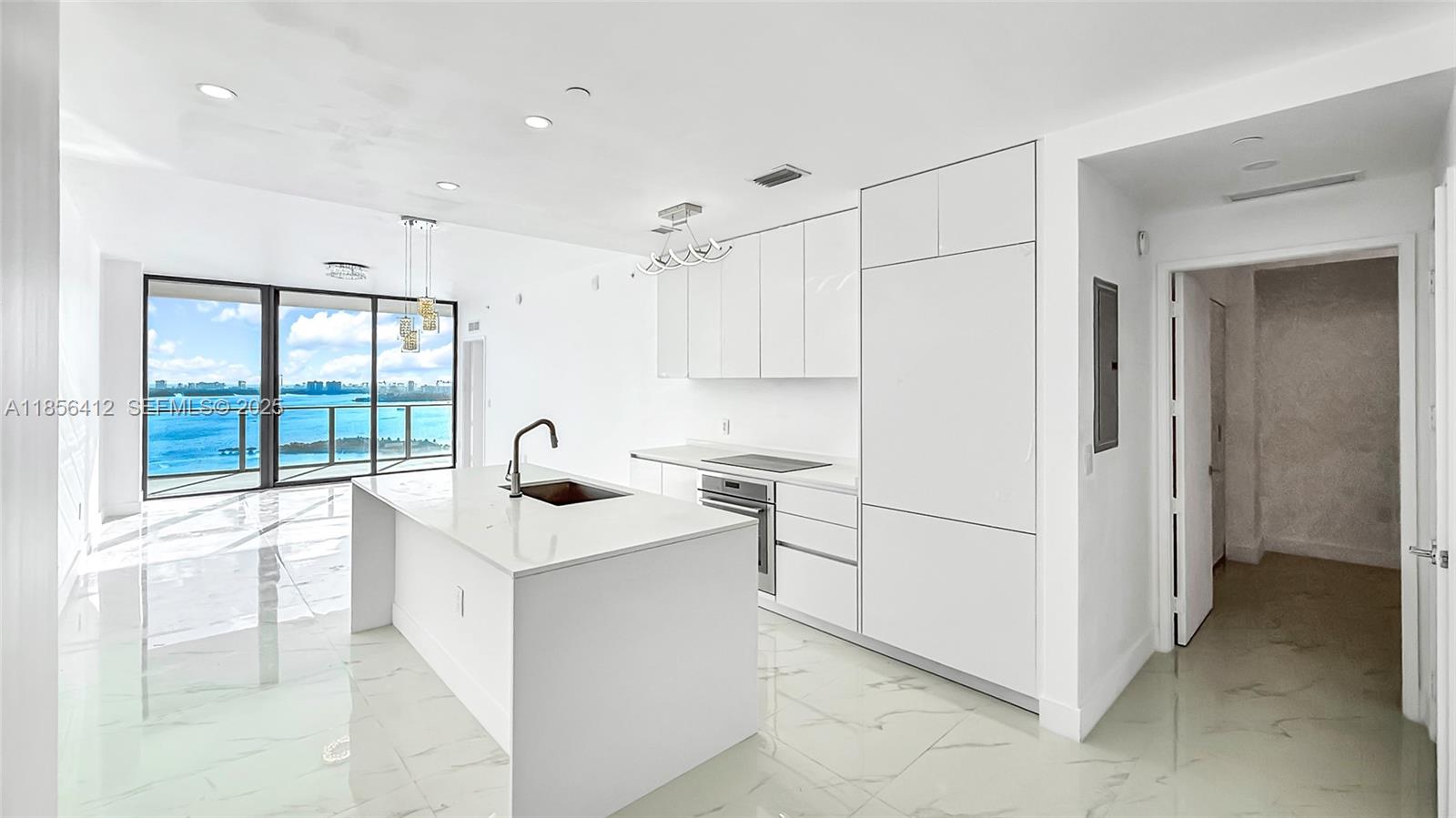 700 Northeast 24th Street, Unit 2704 Miami, FL 33137 - Photo 6 of 88 a kitchen with white cabinets and a sink