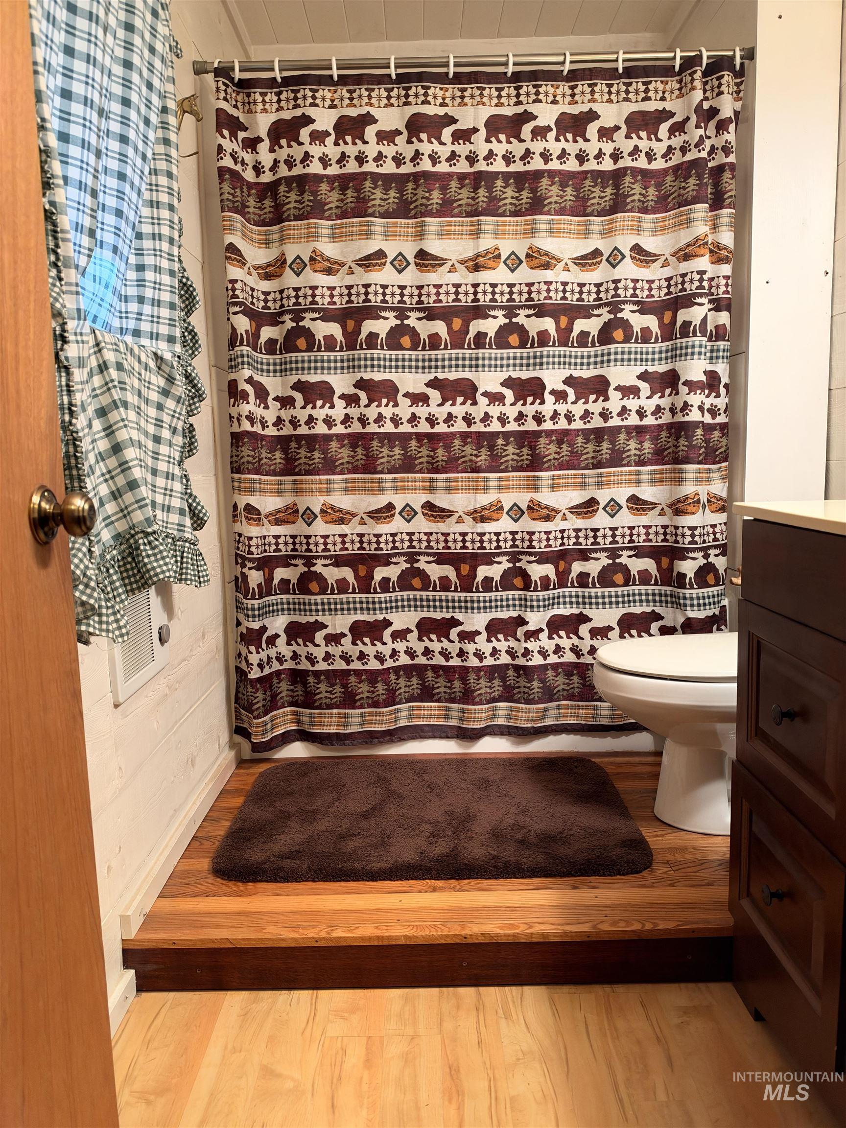 687 Big Cedar Road Kooskia, ID 83539 - Photo 21 of 37 Wood-finish flooring with a raised shower area featuring a white toilet
