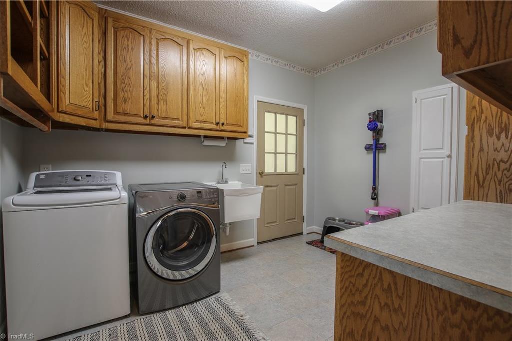 9252 Riverside Road Seagrove, NC 27341 - Photo 26 of 30 Laundry room w/ custom cabinets, door to garage