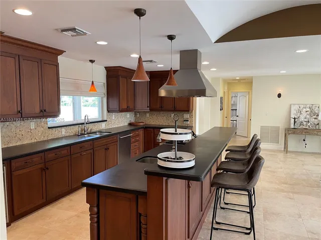 a kitchen with a table chairs sink and cabinets