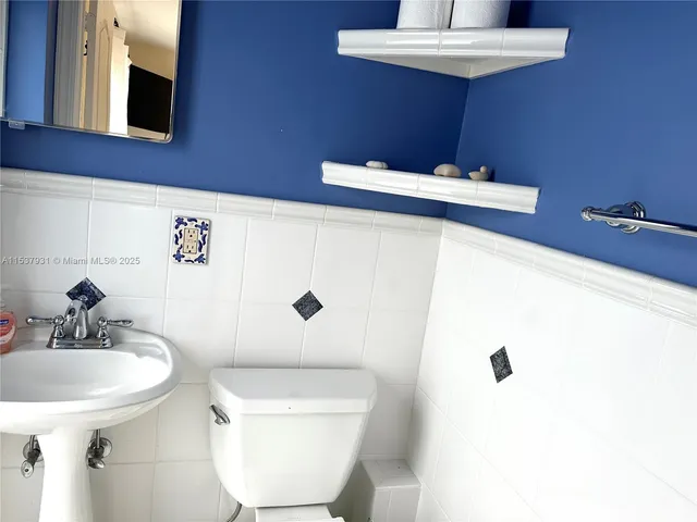 a bathroom with a sink a toilet and mirror