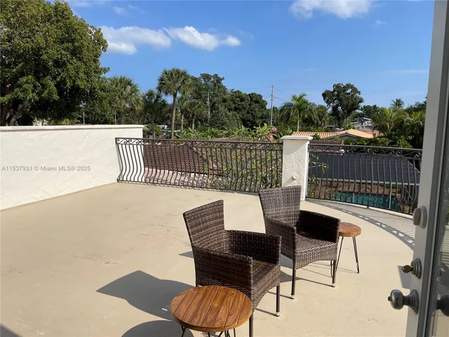 a balcony with table and chairs