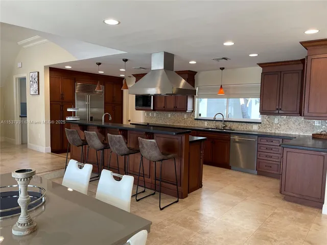 a kitchen with stainless steel appliances granite countertop a sink and a refrigerator