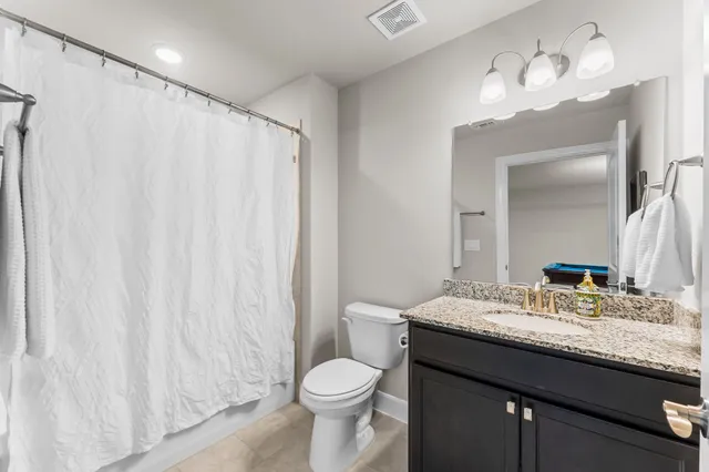 a bathroom with a granite countertop sink toilet and a mirror