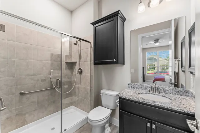 a bathroom with a granite countertop sink toilet and shower