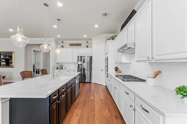 a kitchen with granite countertop a white stove top oven and cabinets