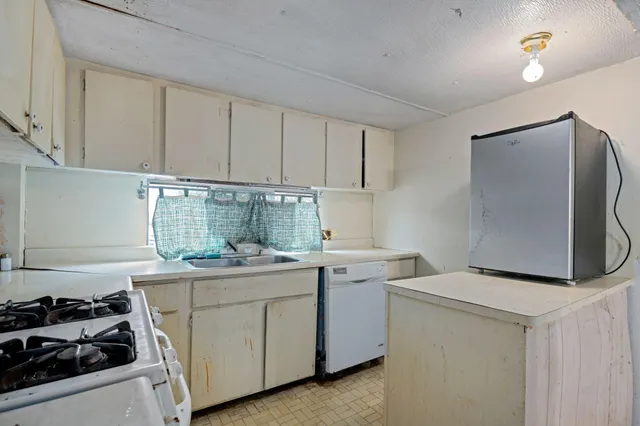 a kitchen with cabinets appliances a sink and a window