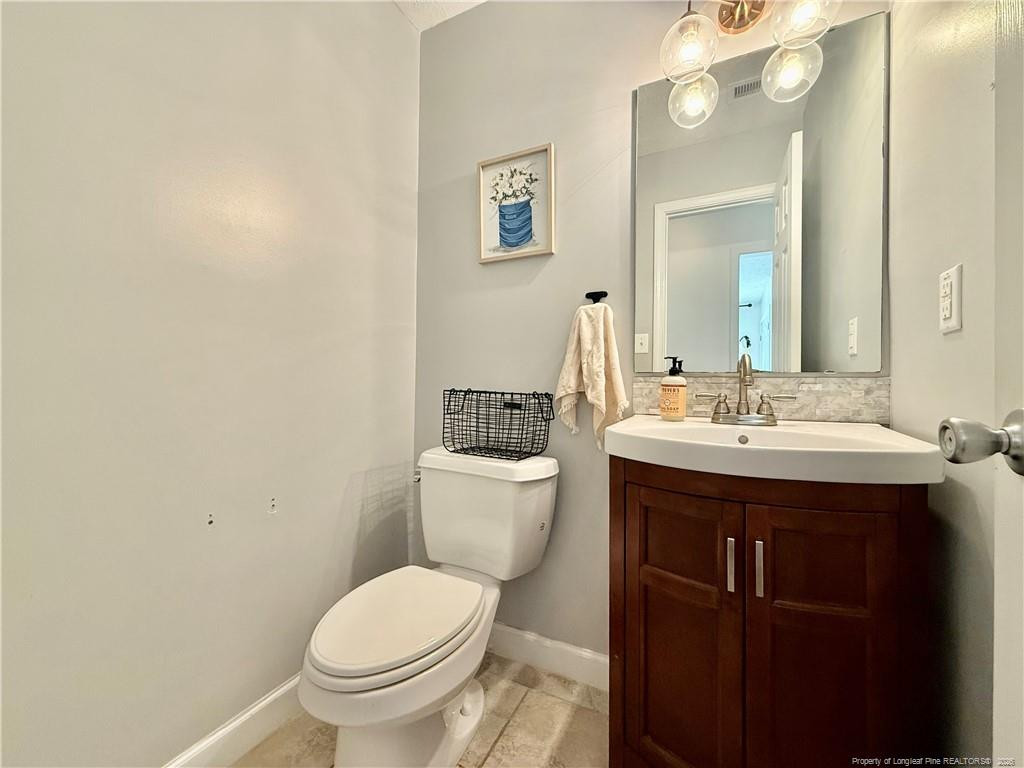 234 Pender Road Spring Lake, NC 28390 - Photo 18 of 39 a bathroom with a toilet a sink and mirror