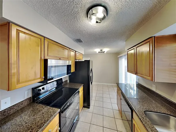 a kitchen with stainless steel appliances granite countertop a sink and a stove