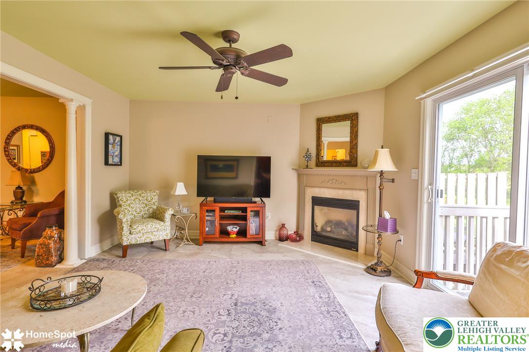 4191 Walter Road Bethlehem, PA 18020 - Photo 11 of 23 A well-lit living area showcases a cozy fireplace and convenient sliding glass doors leading to the exterior.