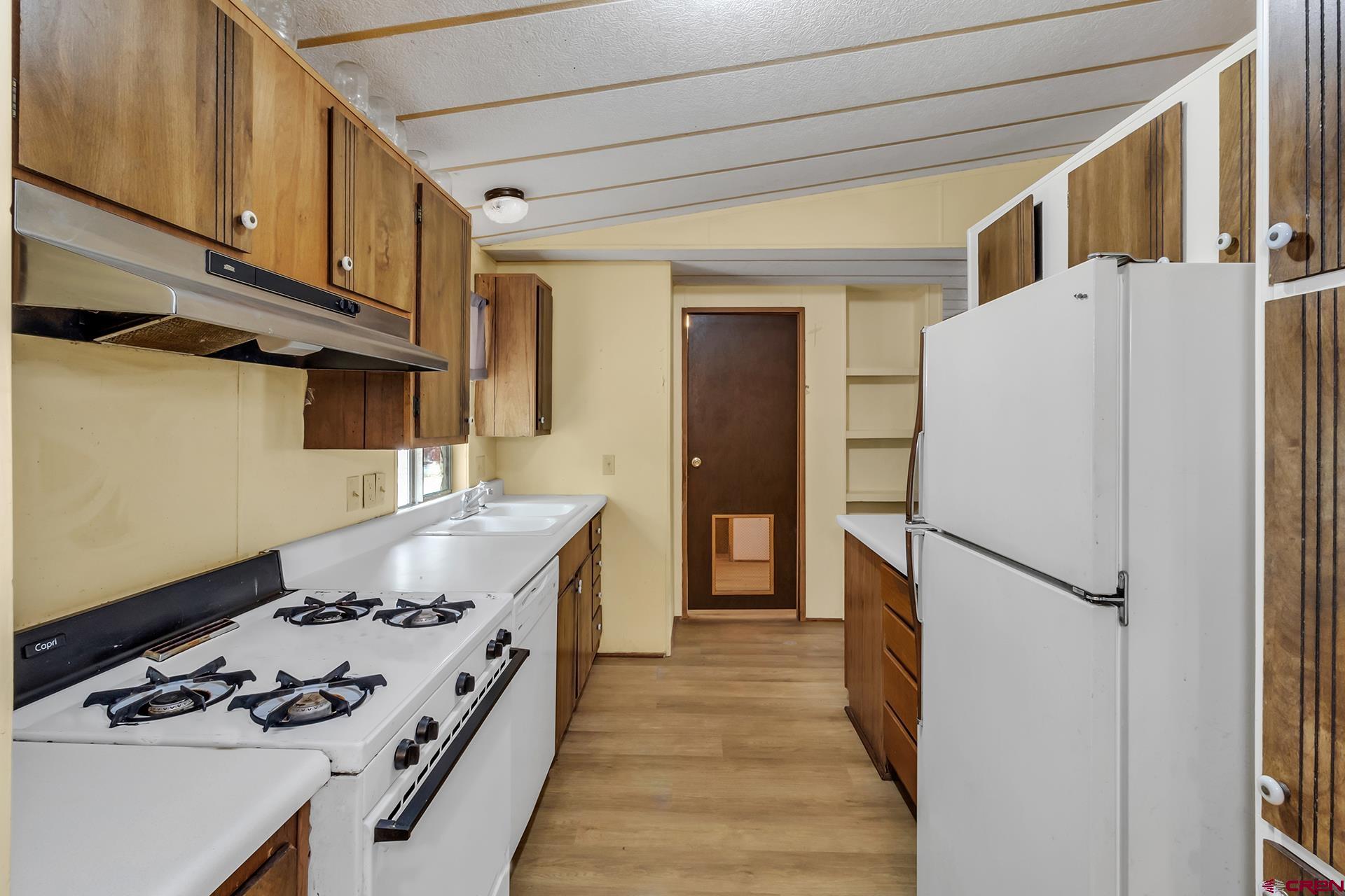 400 Riley Lane Delta, CO 81416 - Photo 11 of 35 a kitchen with a refrigerator a stove and wooden floor
