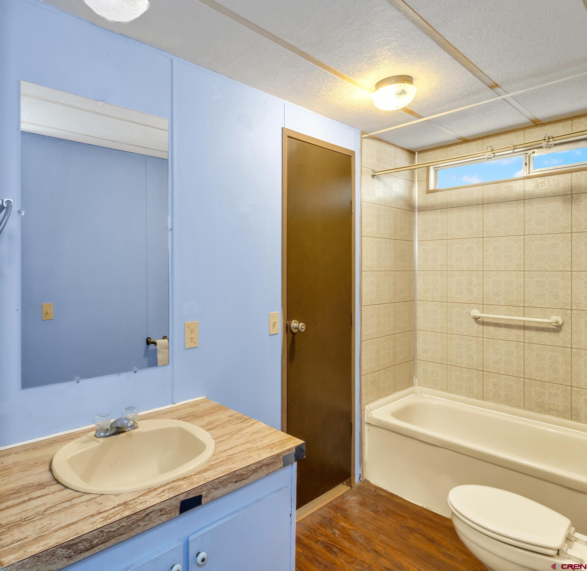 400 Riley Lane Delta, CO 81416 - Photo 24 of 35 a bathroom with a granite countertop sink toilet a mirror and bathtub