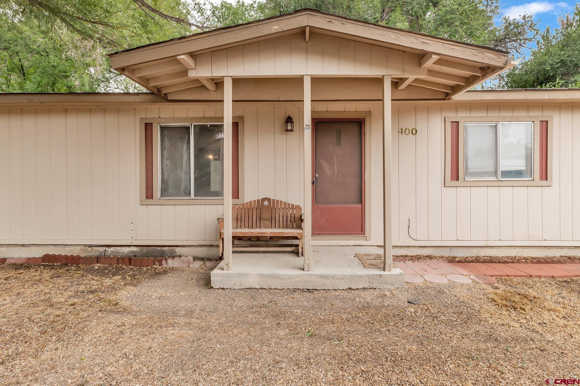 400 Riley Lane Delta, CO 81416 - Photo 5 of 35 a white house with a large window and wooden fence