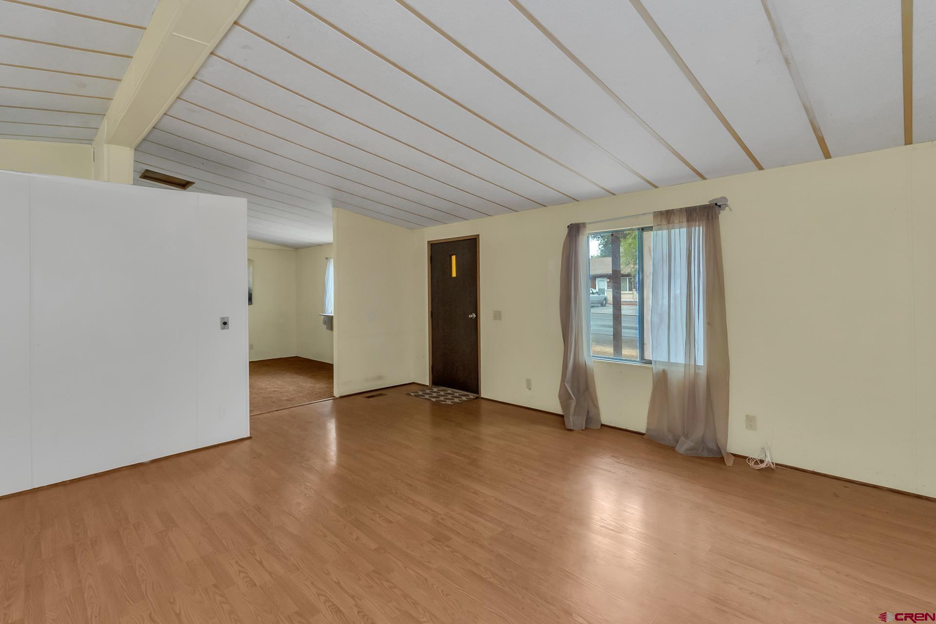 400 Riley Lane Delta, CO 81416 - Photo 9 of 35 an empty room with wooden floor and windows
