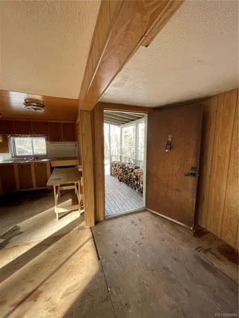 a view of a hallway with wooden floor and livingroom with furniture