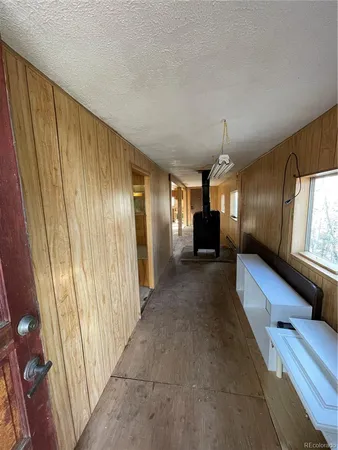 a view of a hallway with furniture and a window