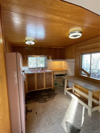 a kitchen with a sink a stove cabinets and wooden floor
