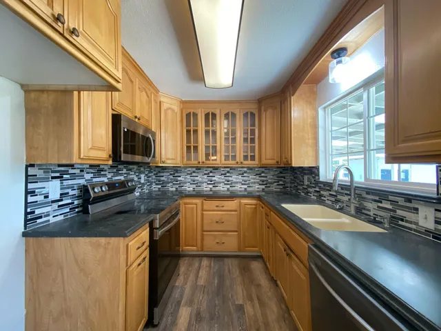 a kitchen with stainless steel appliances granite countertop a sink and a stove