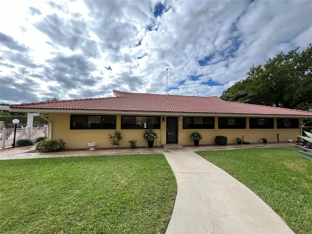 a living room with furniture a flat screen tv and a kitchen view