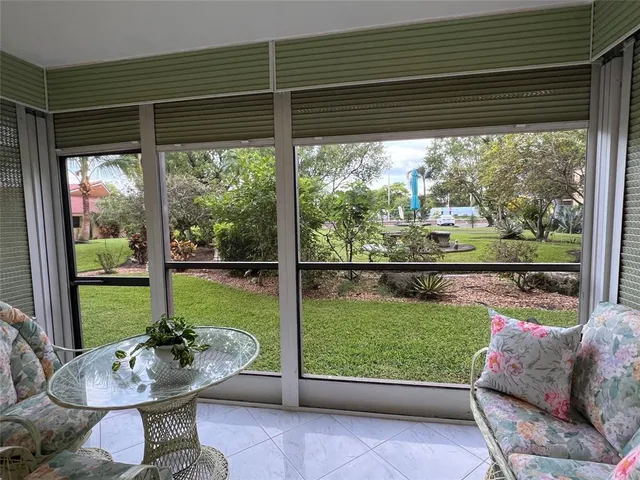 a living room with patio furniture and a potted plant