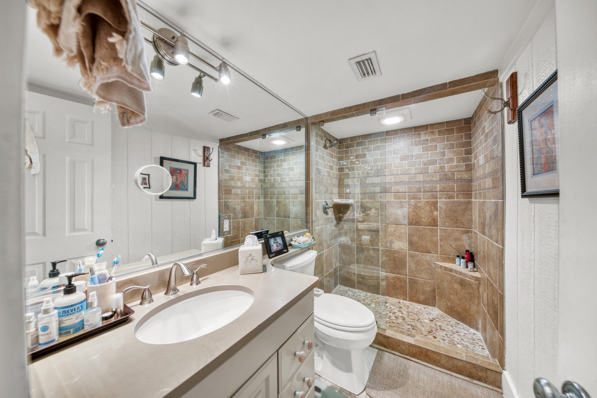 30 Moreno Point Road, Unit 101A Destin, FL 32541 - Photo 12 of 25 a bathroom with a sink a toilet a mirror and shower