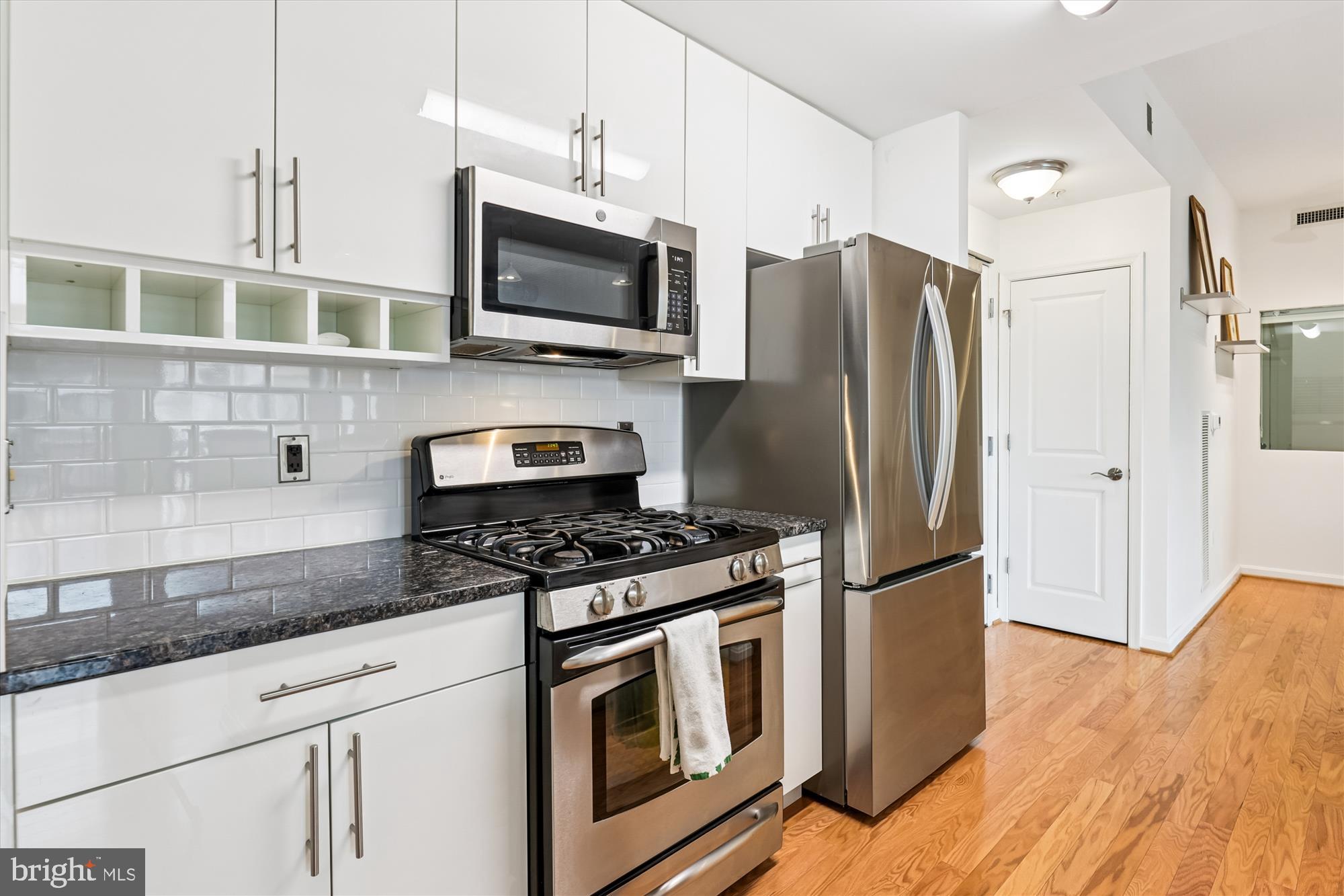 1390 Kenyon Street Northwest, Unit 416 Washington, DC 20010 - Photo 7 of 58 a kitchen with stainless steel appliances granite countertop a refrigerator stove and microwave