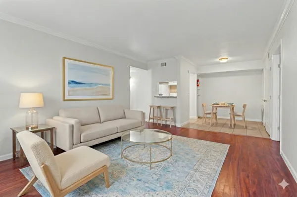 a living room with furniture and a wooden floor