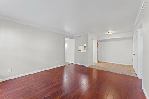 a view of an empty room with wooden floor