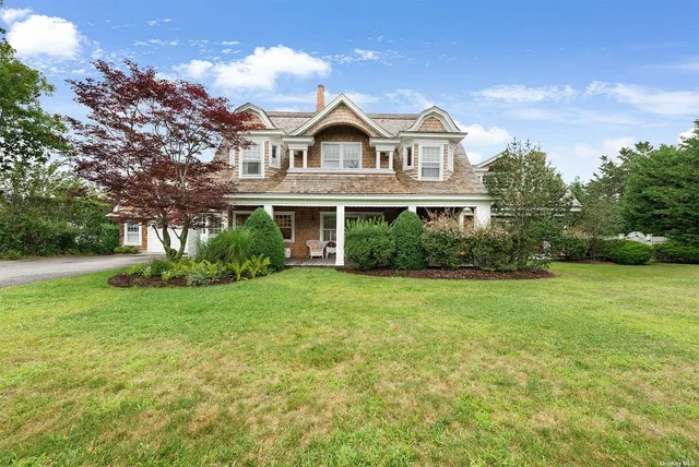 a view of a big yard in front of a house with large trees