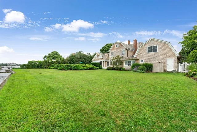 a living room with furniture large windows and wooden floor