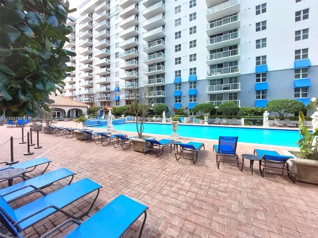 a view of a patio with table and chairs under an umbrella