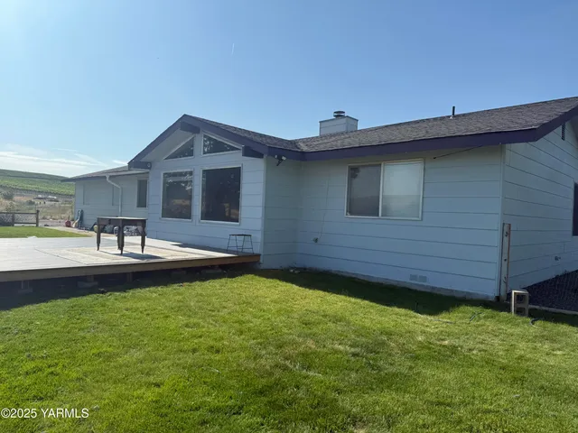 a view of a backyard with table and chairs and wooden fence