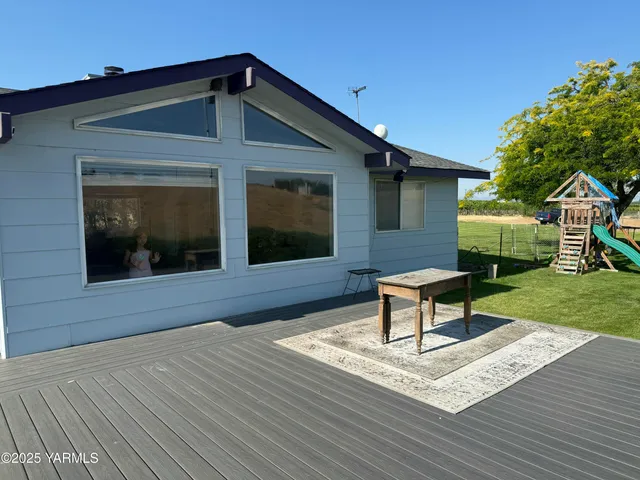 a backyard of a house with table and chairs