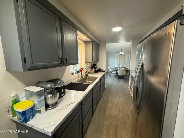 a kitchen with stainless steel appliances granite countertop a sink a stove and a refrigerator