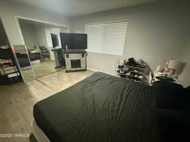 a bed sitting in a bedroom next to a window with tv