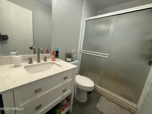 a bathroom with a granite countertop sink toilet and shower