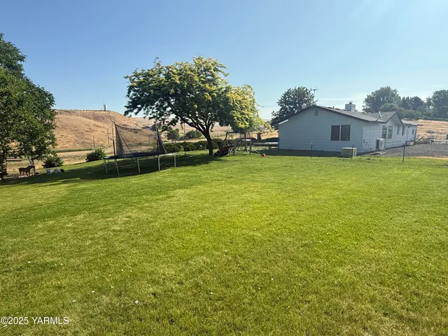 a view of a field of grass and trees