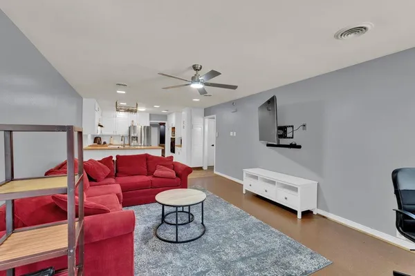 a living room with furniture and kitchen view