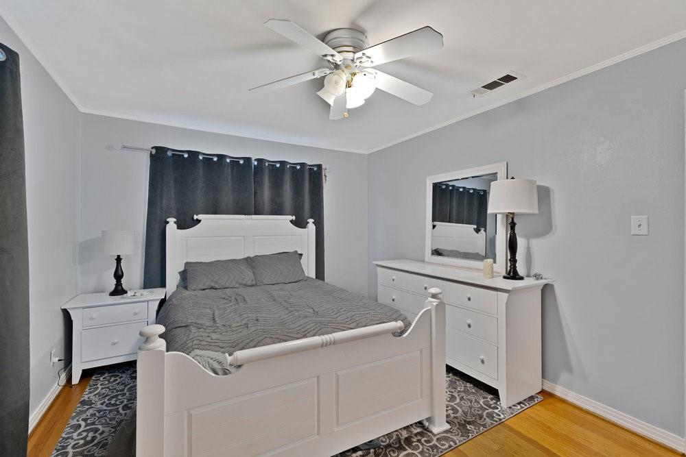 2716 Wayside Avenue Fort Worth, TX 76110 - Photo 15 of 34 a bedroom with a bed and a chandelier