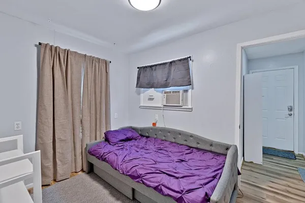 a bed sitting in a bedroom next to a window