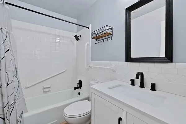 a bathroom with a sink a toilet and shower