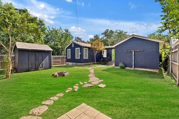a brick house with a small yard and a large tree